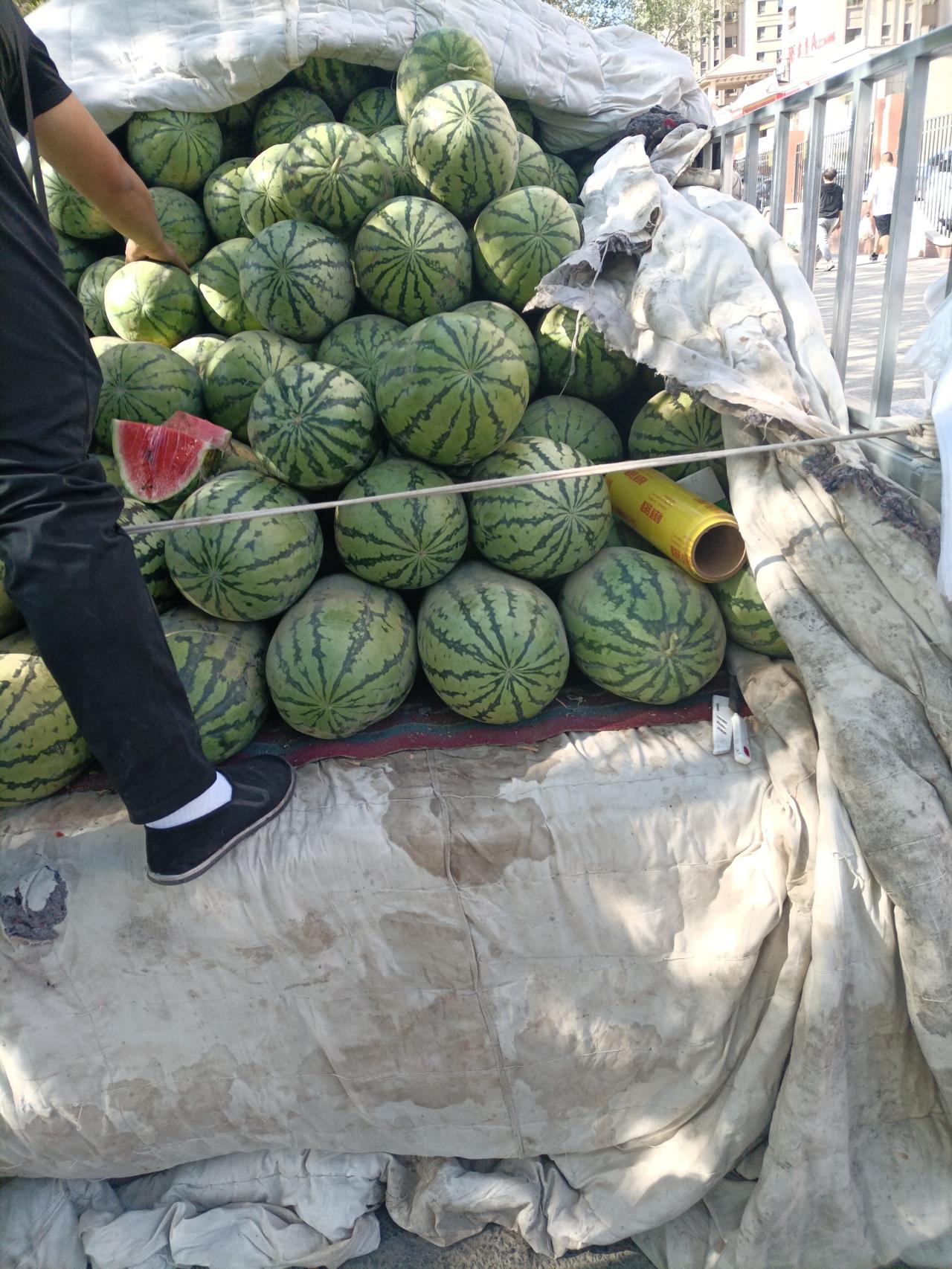 今天上午，我去昌吉富民市场买菜，发现路边流动摊贩西瓜有卖2块钱的，也有卖一块伍的
