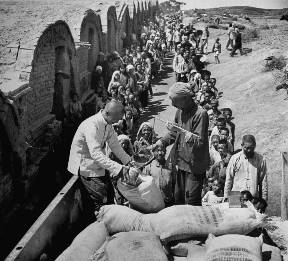 1947年7月21日，上海。来自全国各地的难民排队领救济粮。这里是郊区...