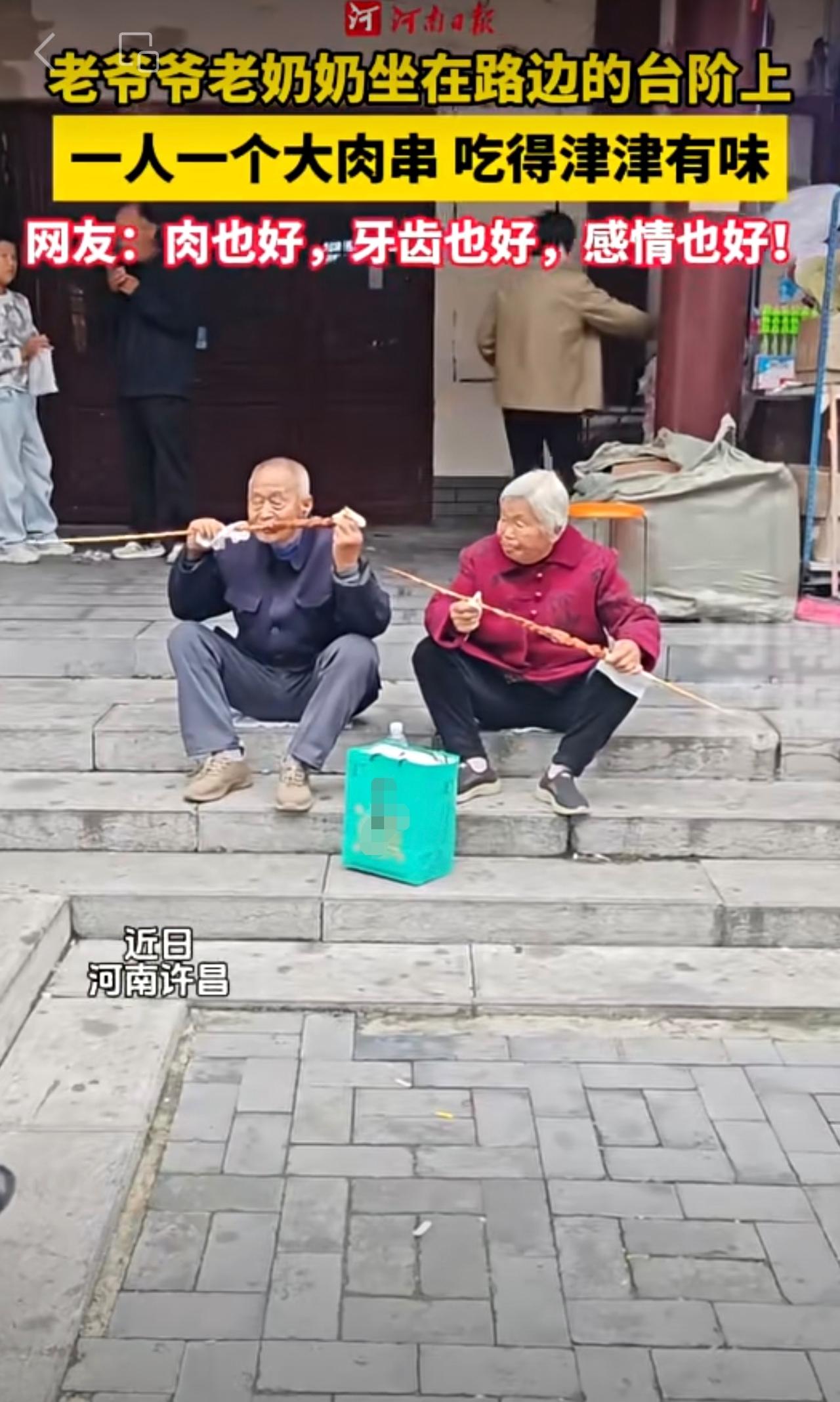 我们老了会不会是这个样子？老爷爷老奶奶坐在路边的台阶上，一人一个大肉串，吃得津津