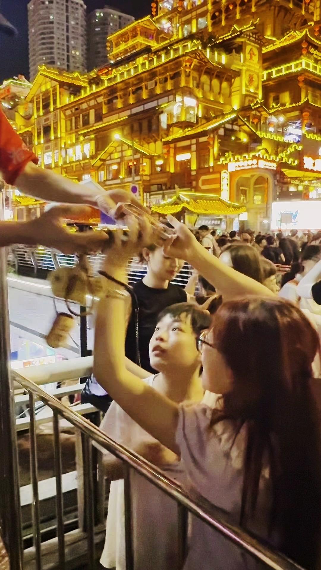 来洪崖洞玩遇到超暖心的一幕，有位默默帮游客举手机拍照的“小蜀黍”，全程话都没多说