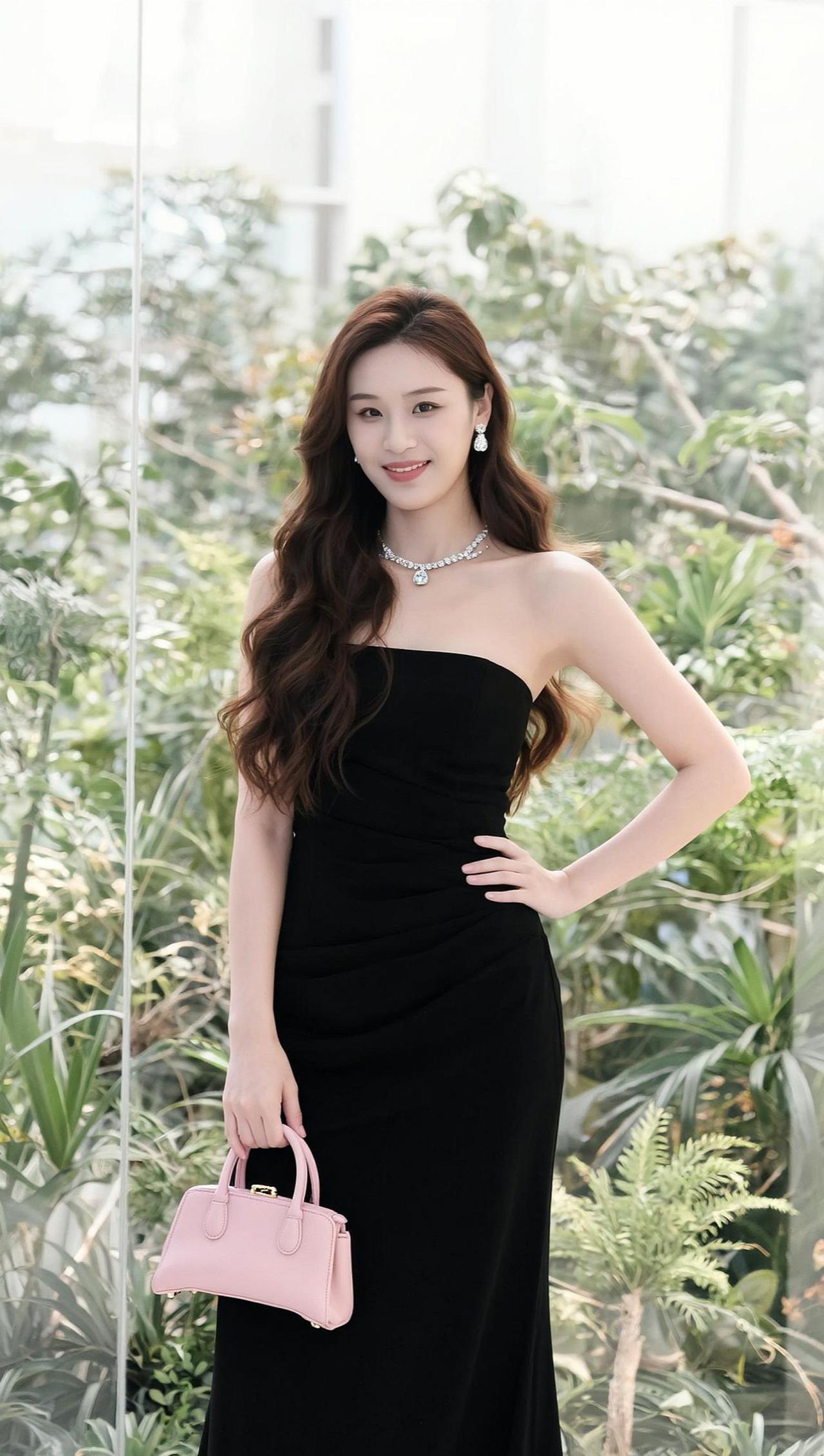 绿意缠绕的玻璃廊道里，她如一帧静止的旧时光画报。黑裙勾勒出恰到好处的曲线，珍珠项