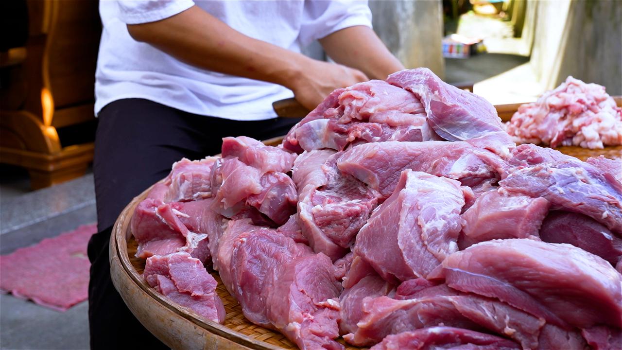 一对夫妻正延续着祖辈传下的手艺。夫妻俩配合默契，切肉、配料，翻炒。没有机器轰鸣，