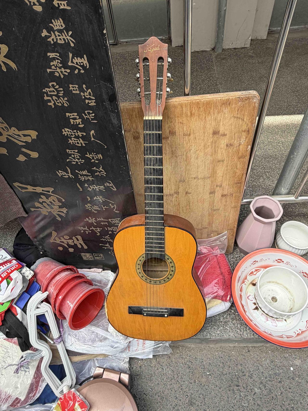 前两天，我逛西安档子，在西仓南巷，看到一个摊位卖吉他，不由停下脚步。
这把吉他，