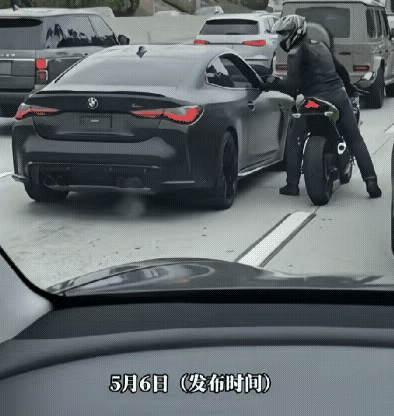 一名摩托车骑手在路上多次别车、挑衅该黑色轿车。
​
轿车靠边、车窗降下后，骑手仍
