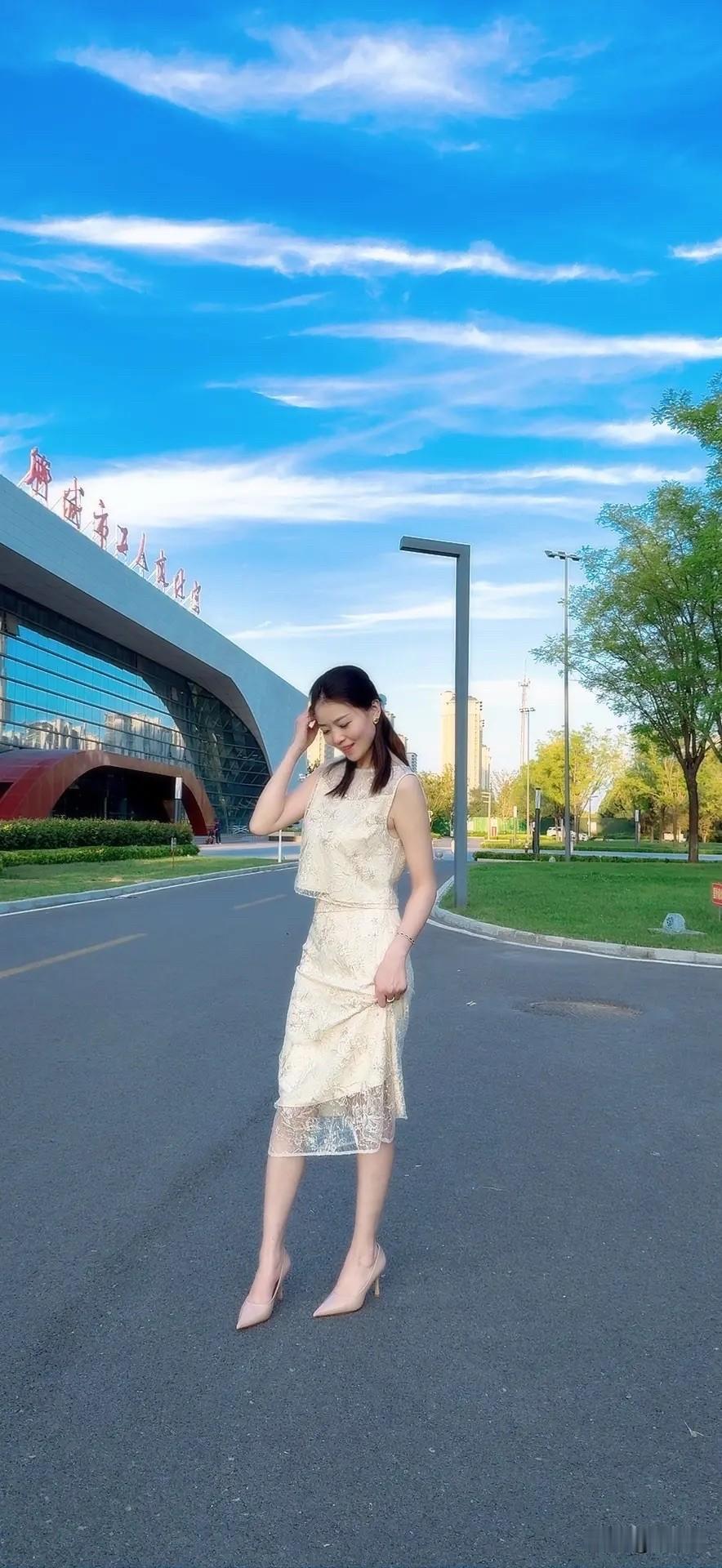 阳光明媚，她穿着裙子在户外。