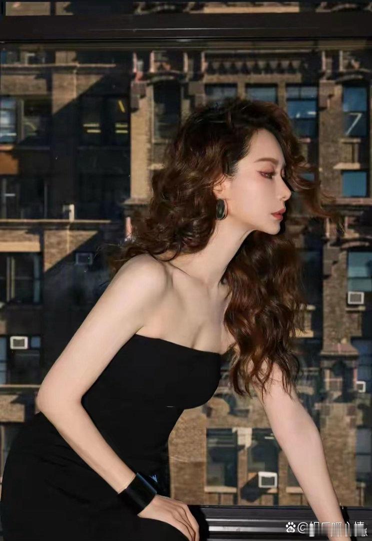 戚薇身穿黑色抹胸短裙，利落剪裁勾勒曼妙身姿，慵懒羊毛卷搭配墨镜，酷飒氛围感拉满，