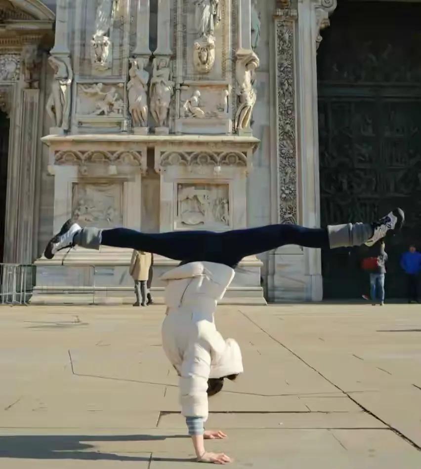 她倒立在米兰大教堂前，羽绒服都没脱。
你猜意大利游客举着手机在拍什么？
不是教堂