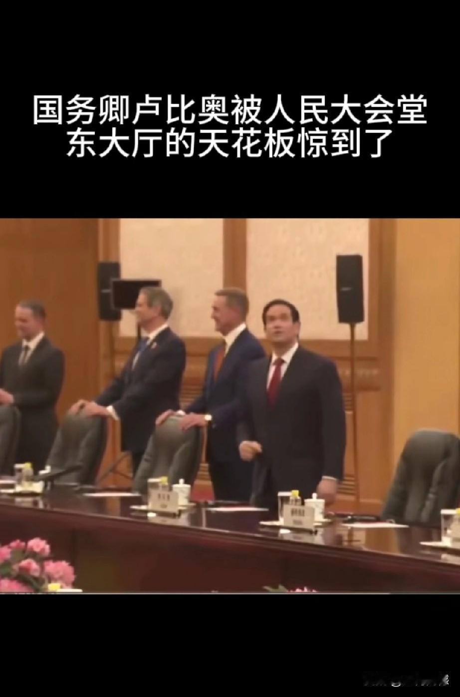 卢比奥被人民大会堂东大厅的天花板吸引住了，跟同行人说着什么，并用手指指点点，也不