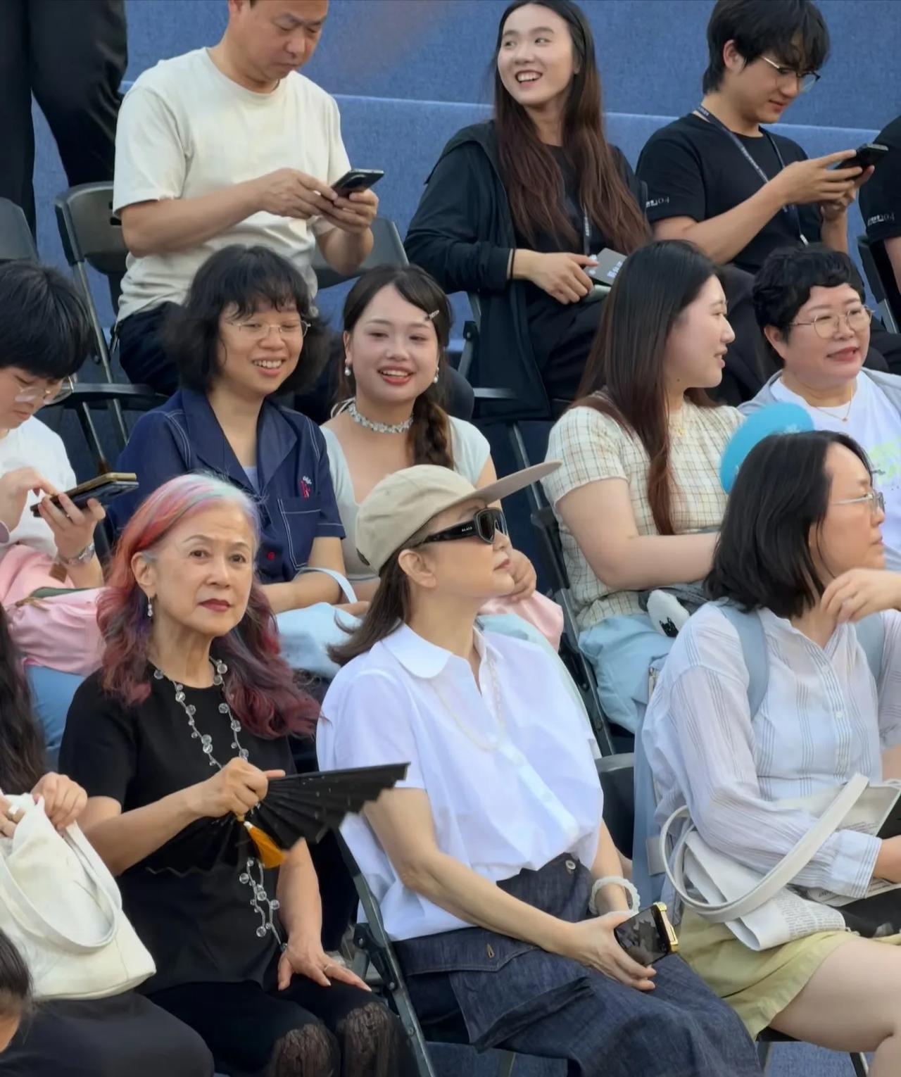 林青霞旁边这位女士，
虽然头发花白，
但染了好几种颜色，
看起来非常时尚，
气场