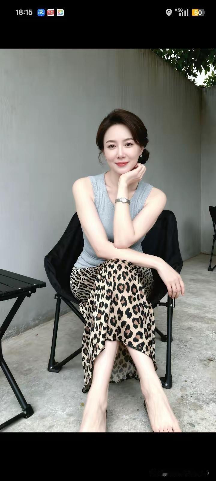 一位女士坐在椅子上微笑。