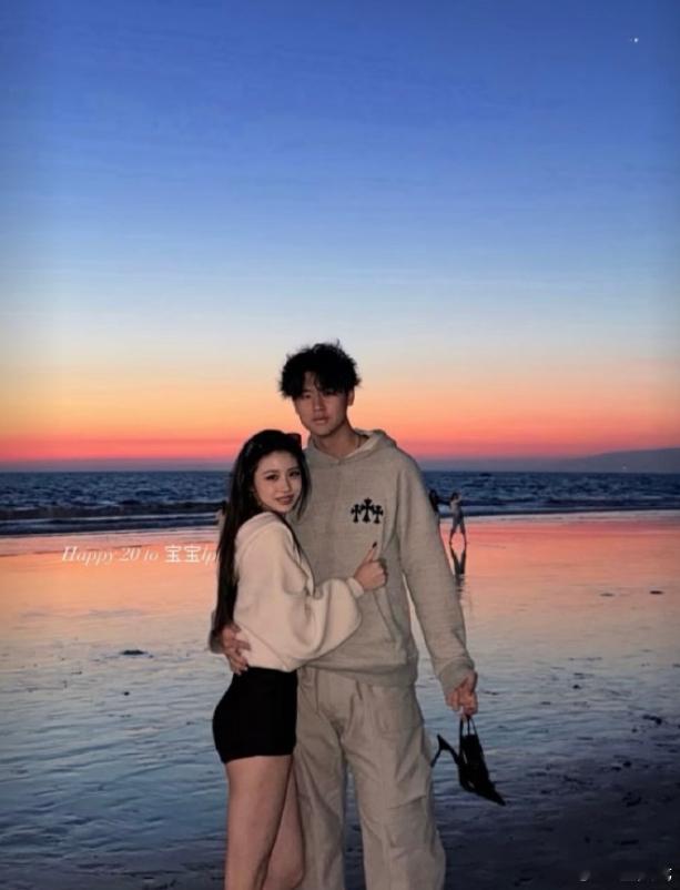 汪峰女儿小苹果在社交平台晒与一年轻帅哥搂腰拥抱照，二人在海边夕阳下甜蜜相拥，男生