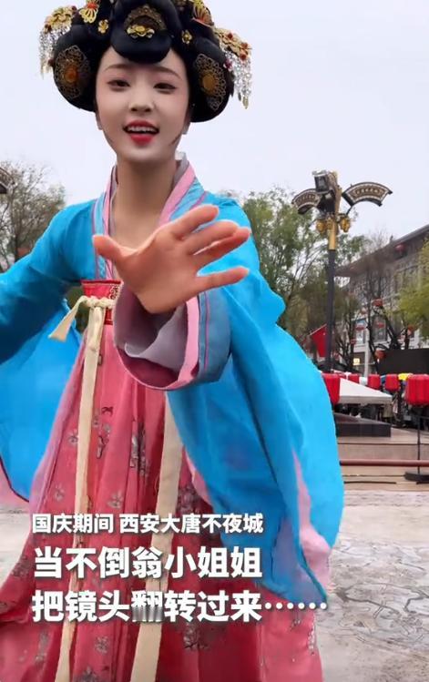 近日，西安大唐不夜城，不倒翁小姐姐表演时，竟然一时兴起，把游客手机抢了过去，将镜