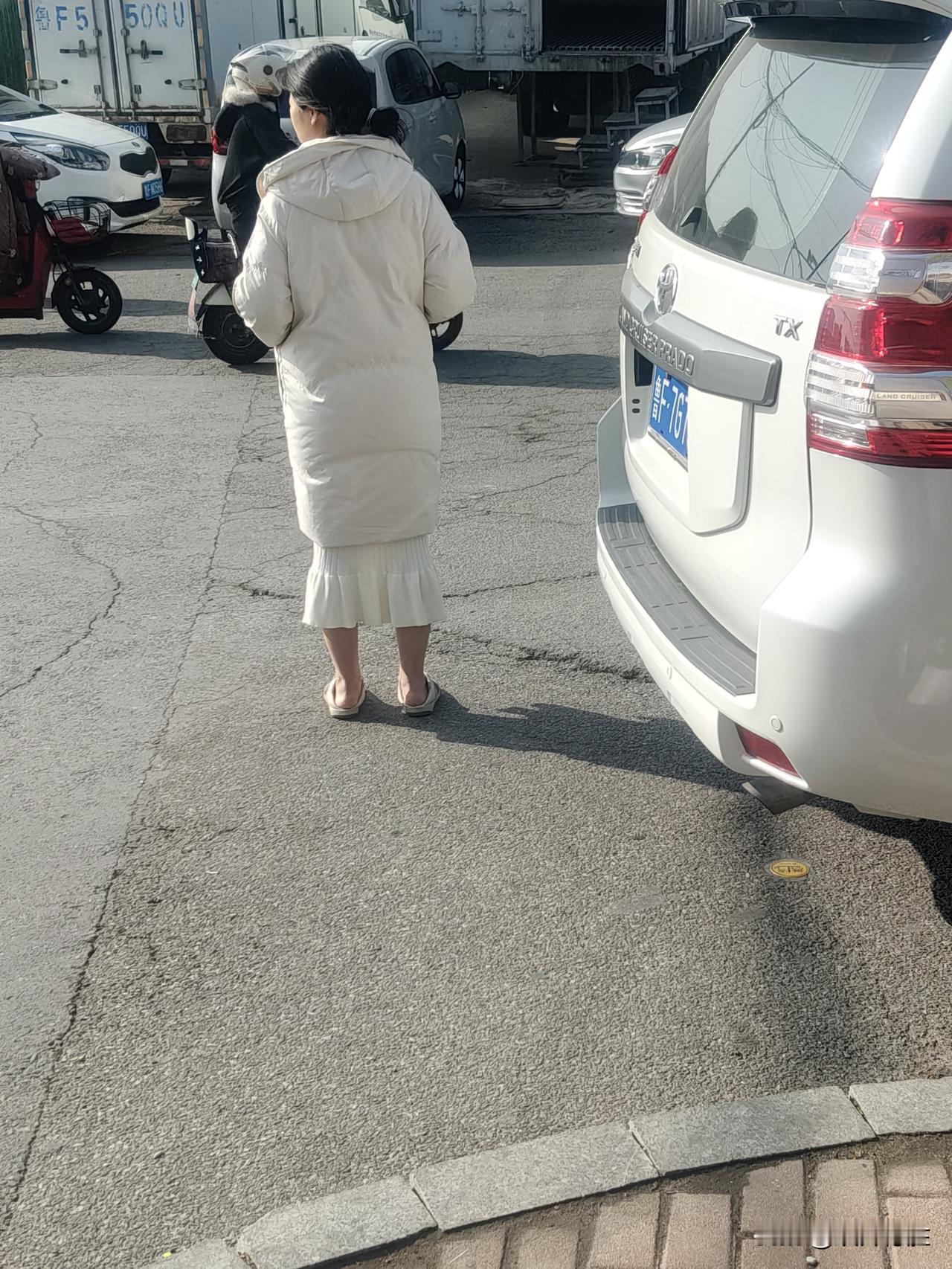 这样的穿着打扮也真是太没有品味了：外面穿着长款羽绒服，里面穿着鱼尾裙，光脚穿着拖