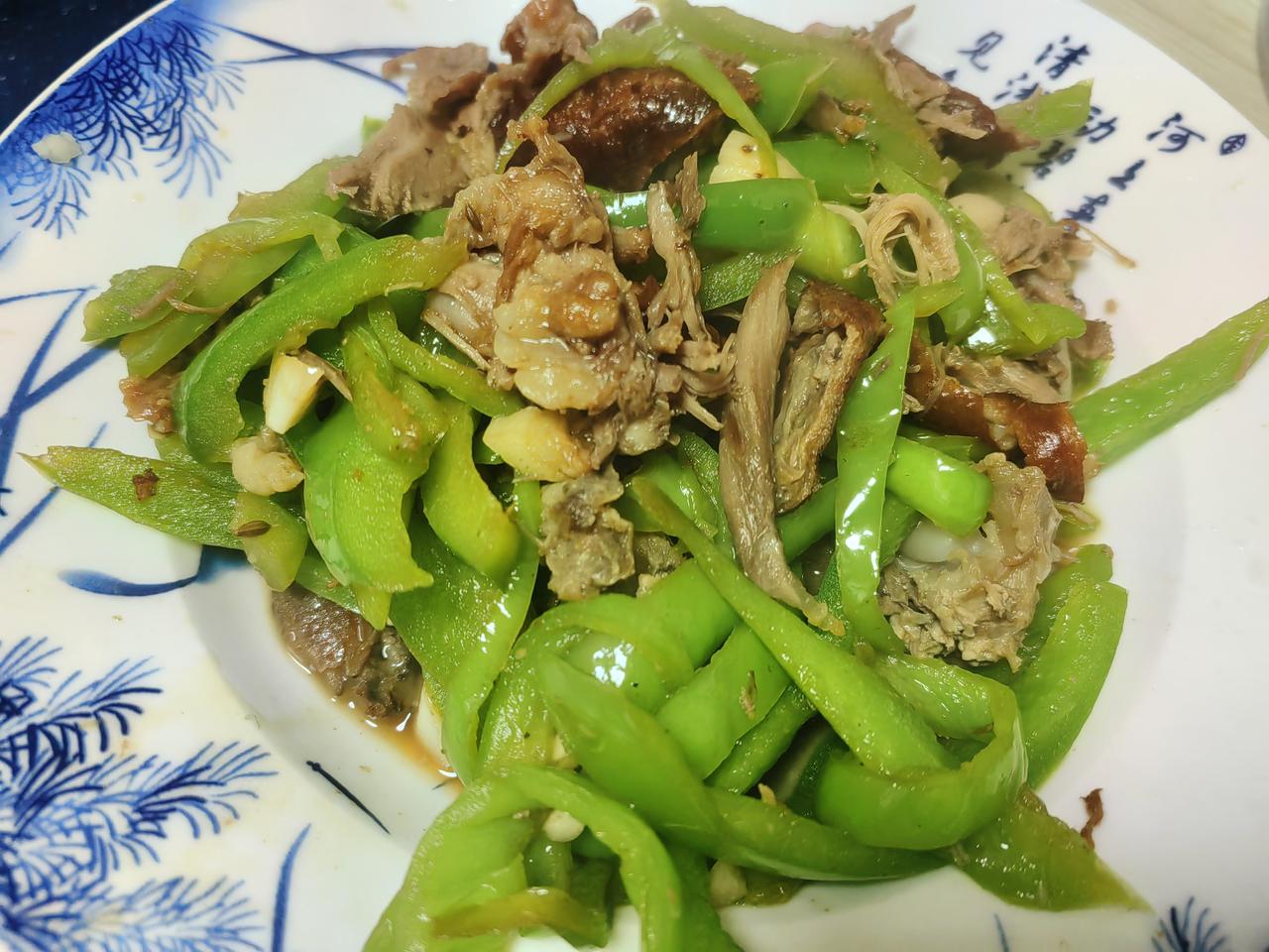 中午将昨天饭店带回的烤鸭架子上的剩肉手撕下，配了一根尖椒半个青椒切丝炒了，配米饭