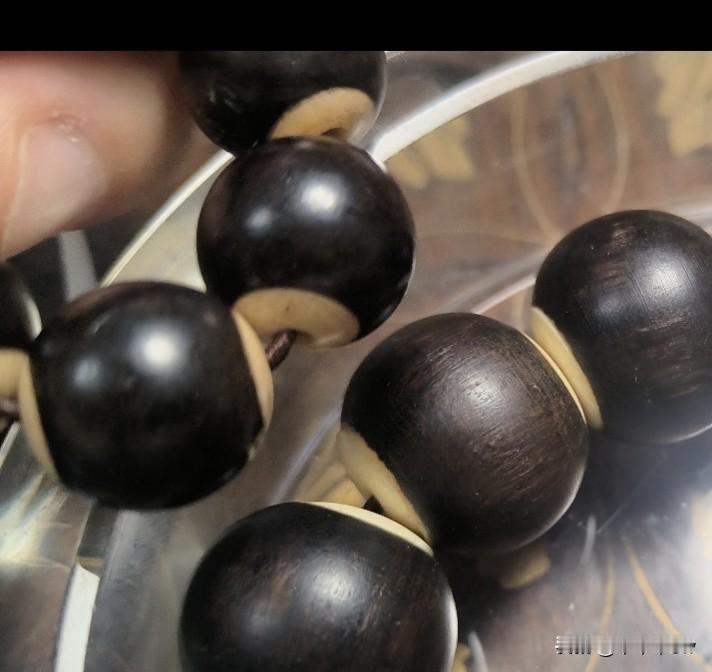 玩沉香确实考眼力。我今天翻到一张老图，然后挺有趣的。
这里面两串珠子，一串是黑檀