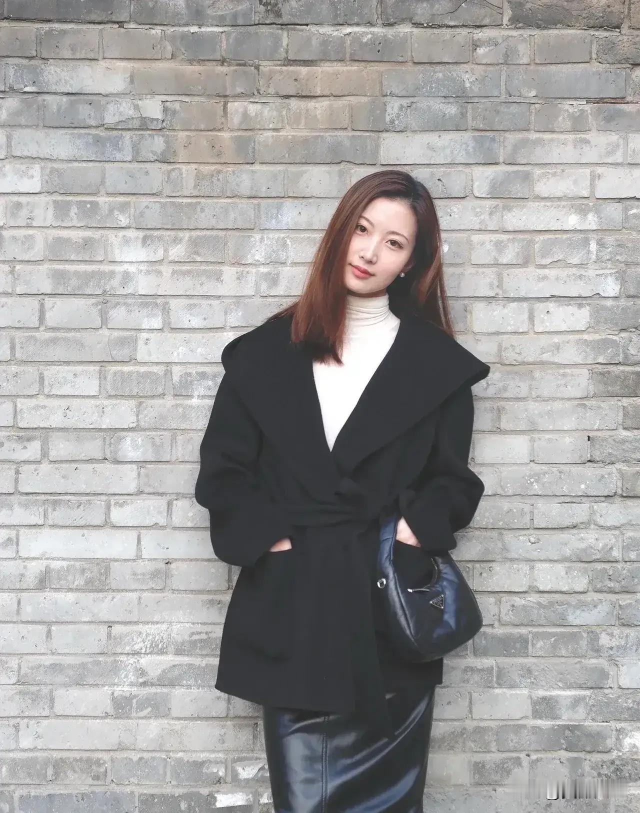 黑衣美人倚墙立，风姿绰约似画卷。