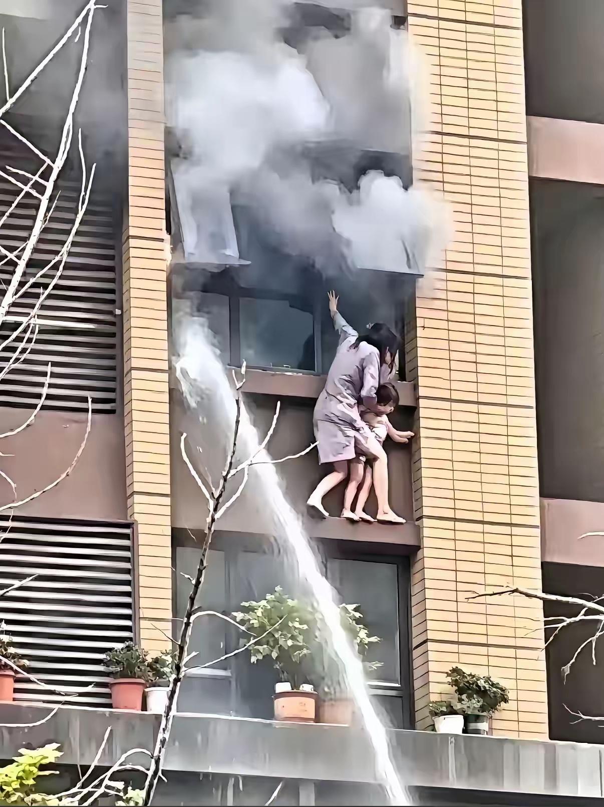观看视频。起初，母亲扶着窗户，状态还算平稳，此时窗户并无明火，浓烟向上飘散，根本