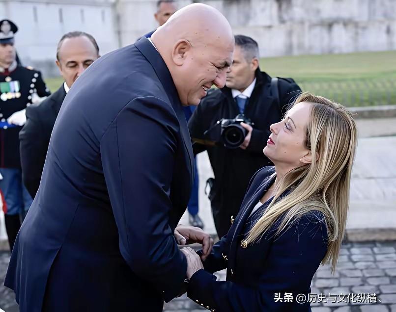 面对高大威猛的国防部长弯腰一脸谄笑，梅拉妮高昂着头，正脸保持了她的矜持：这支意大
