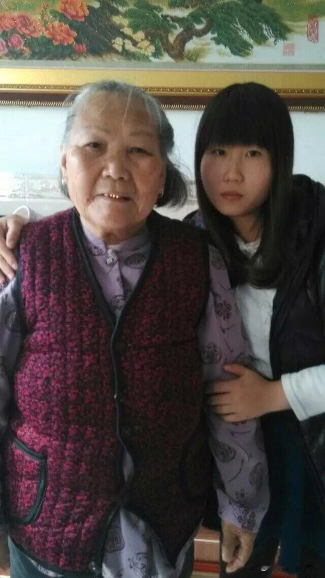 祖孙间的温暖时光
 
照片里，奶奶穿着带花纹的紫色衣衫和红黑相间的马甲，满脸岁月