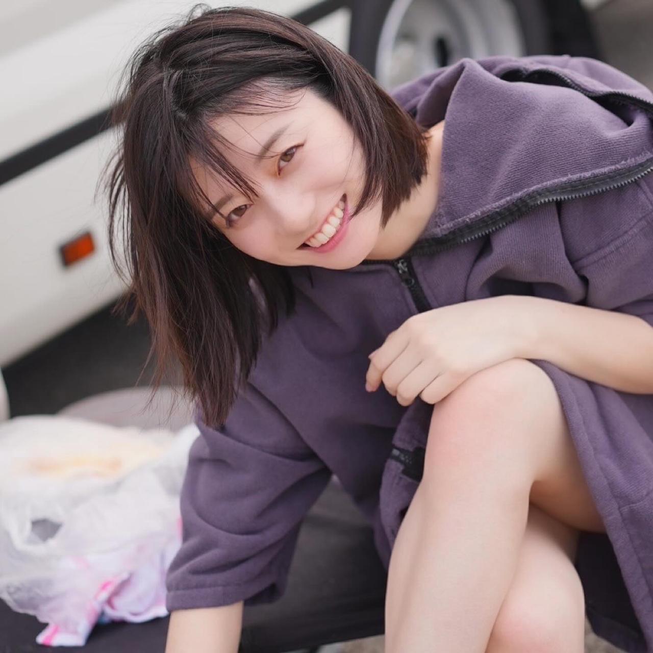 阳光女孩在车旁开心微笑。