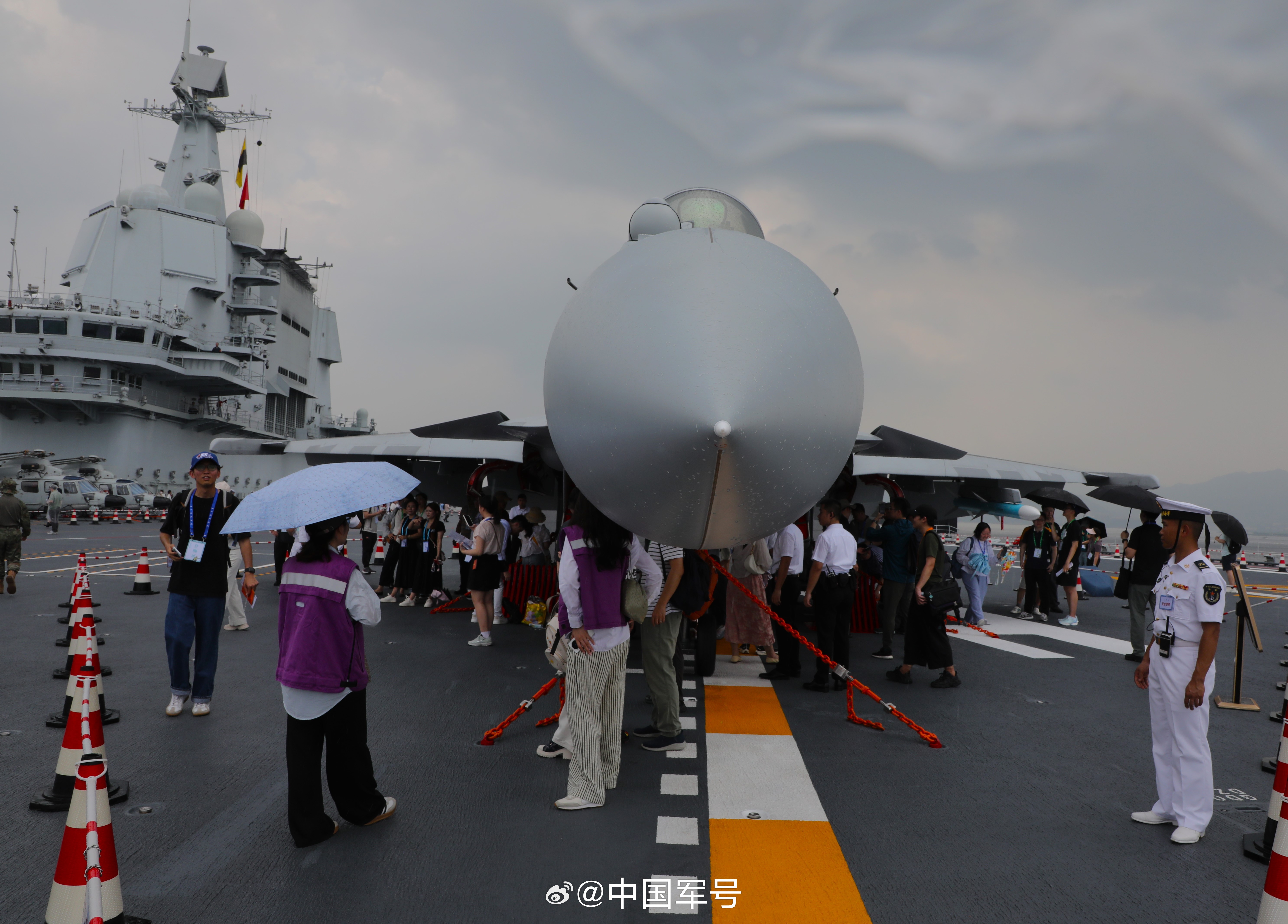 【最安全的“避风港”！香港市民舰载机下躲雨】7月5日中午，山东舰开放期间，突遇降