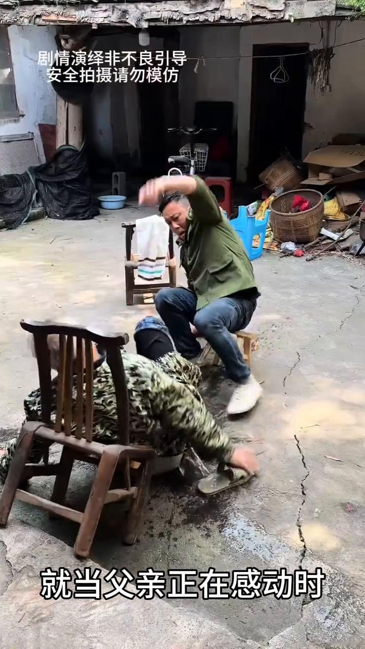 孝顺的儿子给父亲洗脚时。
儿子坐在椅子上给父亲洗脚，就当父亲正在感动时，谁知他不