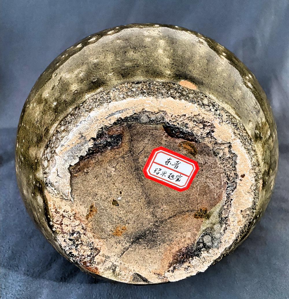 拆解这件东晋越窑底足的关键特征：

一、垫烧痕迹的本质：不是“瑕疵”，而是时代工