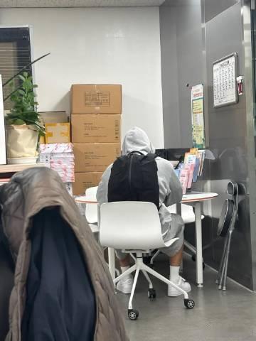 金珉奎不明显上班头像金珉奎背书包工位背影，一身休闲外套，帽子遮挡脸庞，安静坐在工