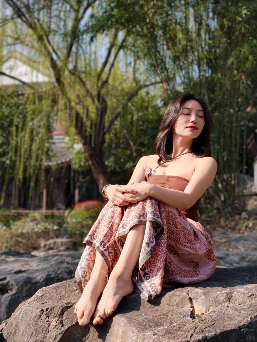 风携着春日的暖意漫过肩头，阳光透过枝叶的缝隙，洒下细碎的金芒，落在衣摆上，漾开温