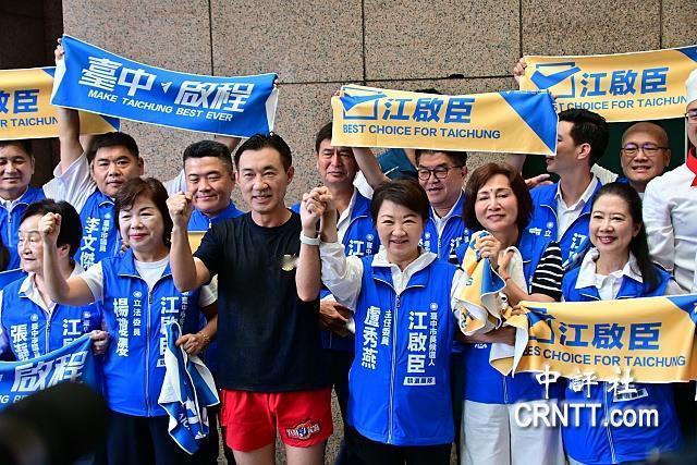 国民党台中市长参选人江启臣今天上午赴市选委会登记参选，特别穿着海龙蛙兵服装冒雨路