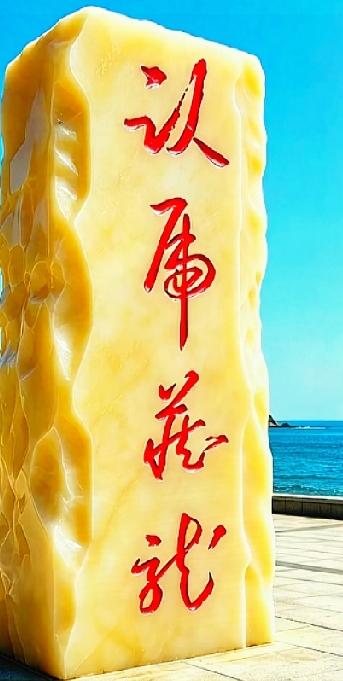 这块玉石石碑上的字，你能完整读出来吗？

海边玉石立石刻着四个竖排草书，笔画连绵