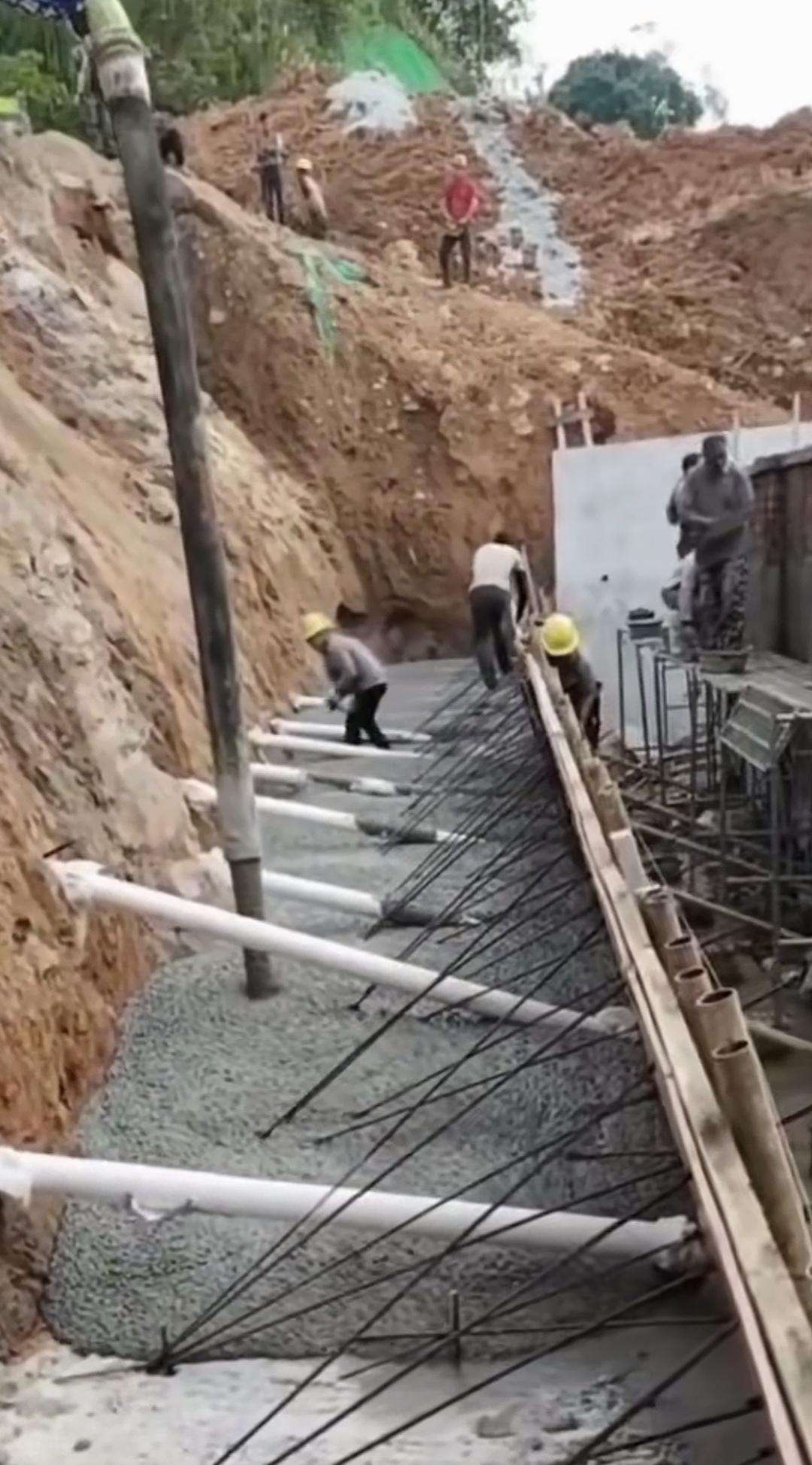 住宅旁挡土墙偷工减料，雨季滑坡风险飙升！
临近在建房屋的边坡挡土墙，本应预埋钢筋