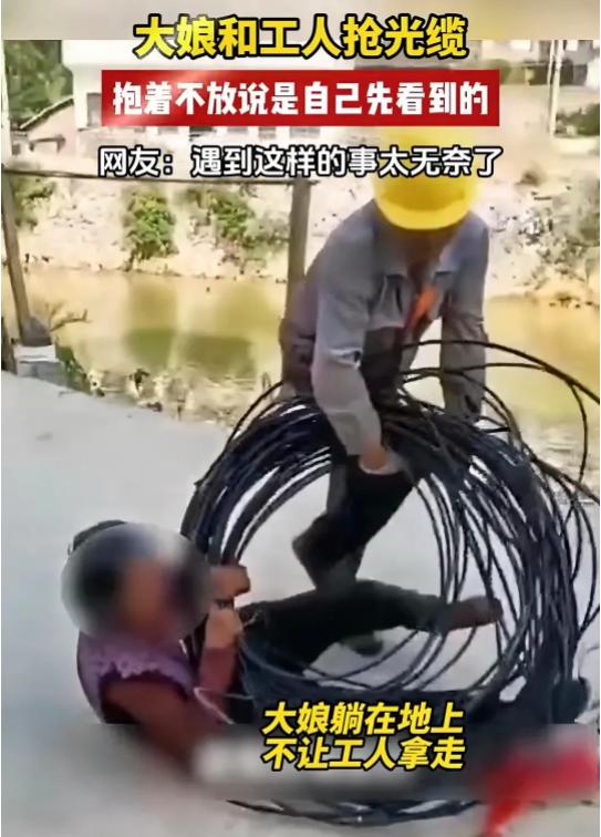 湖南，大妈看到一捆光缆，急忙上前想要抱回家中。这时，工人走过来，说这是他们的，要