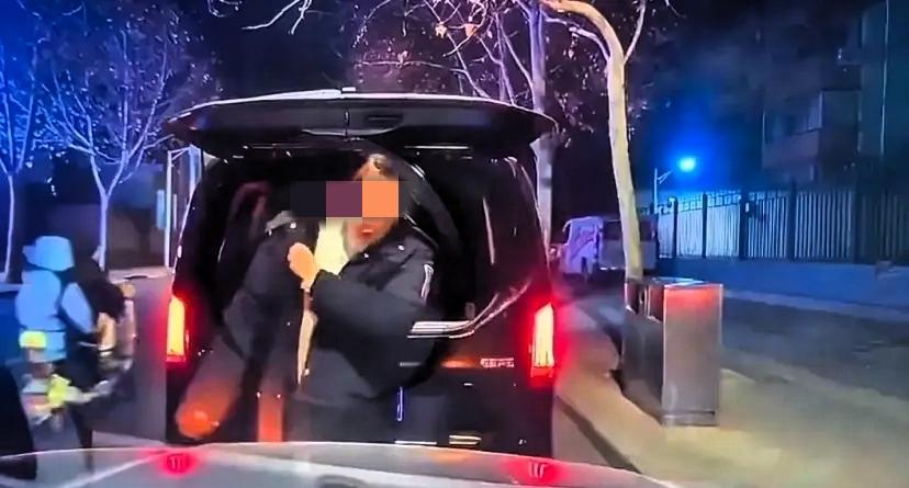 某街道，两个女车主因为冲突在路边等待交警的到来。奔驰女车主从后备箱拿出一件公安大