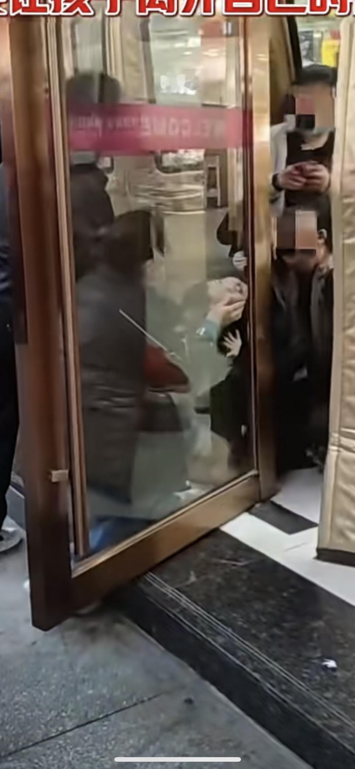 12月10日，男孩玩耍头卡住商场大门缝隙，妈妈在旁边心疼哭喊“妈妈在”，孩子被卡