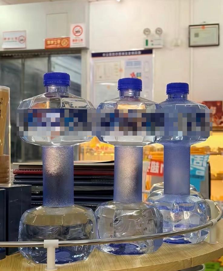 大号塑料水瓶，这些水瓶被巧妙地设计成哑铃形状，配有六边形配重块和中央握把，既可用