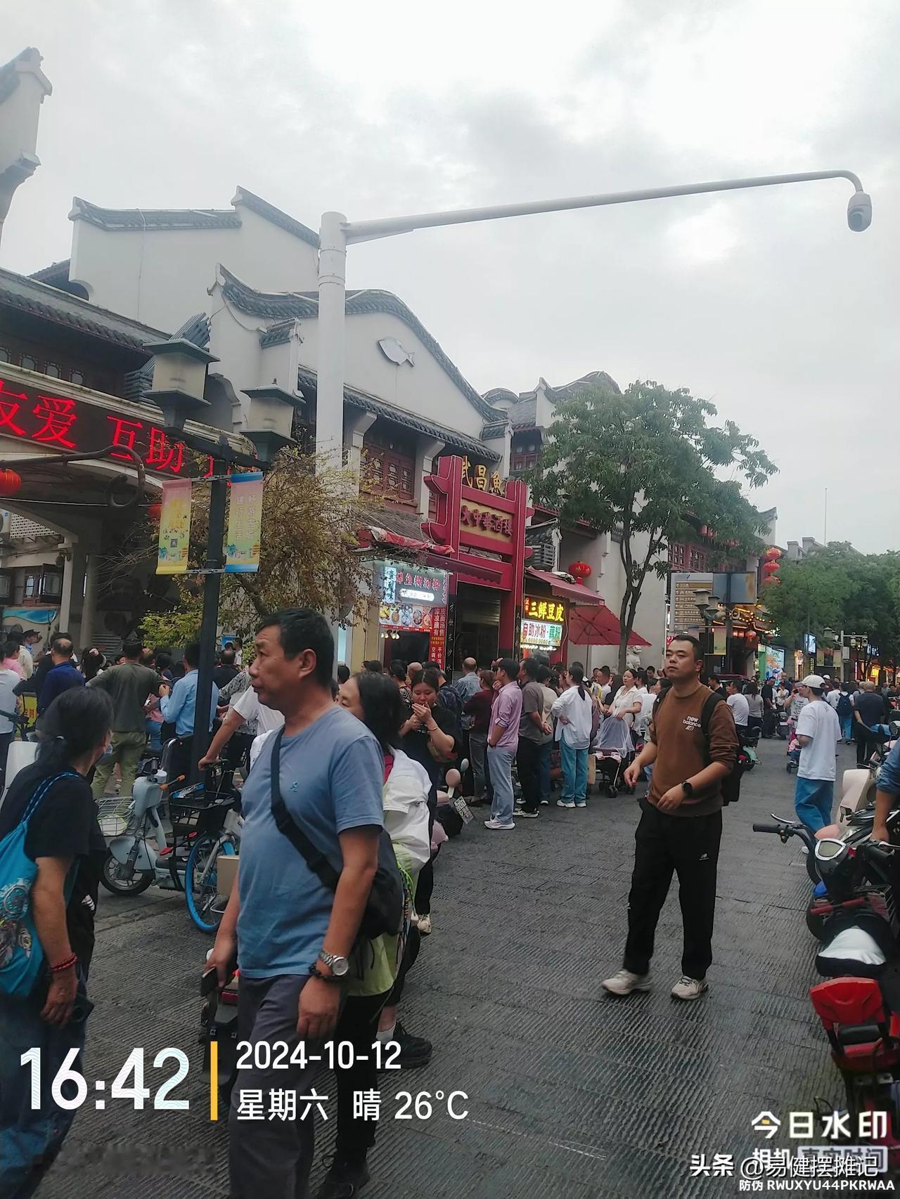 户部巷一群游客看到一群人伸着脖子在观望，还以为又是户部巷的某项旅游景点，挤进去才