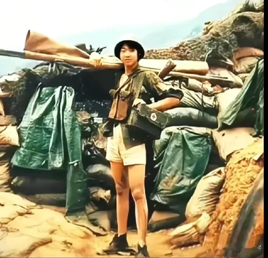 老山轮战，一名火线救援队女兵的留影，头戴钢盔、左肩挎急救箱，右肩扛着担架，斜跨钢