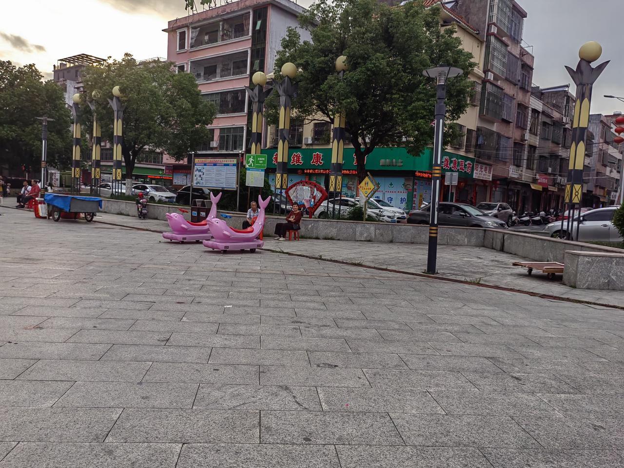 城市街头的悠闲时光，粉色的独角兽滑梯引人注目。