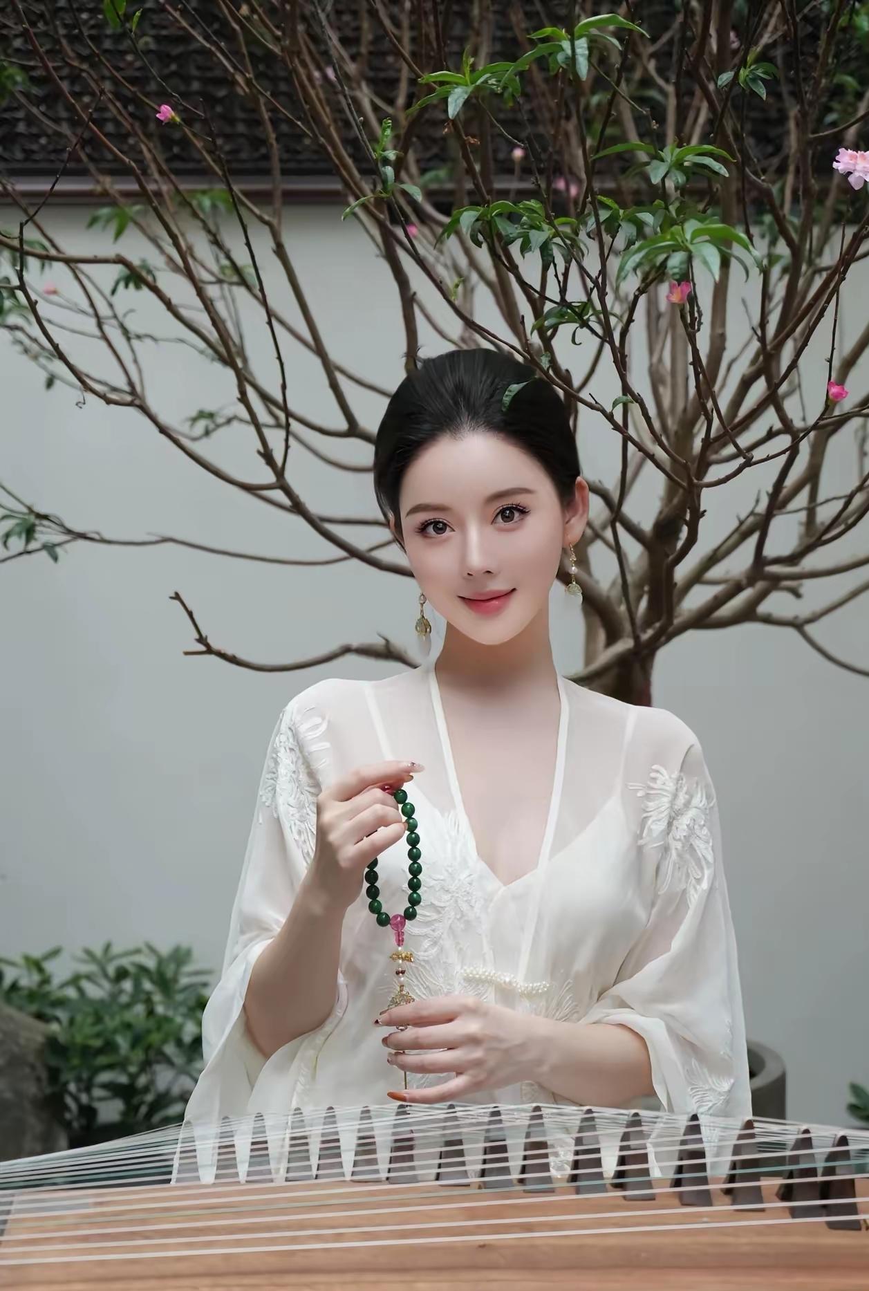 一袭素衣，抚筝弄弦，指尖流转千年风雅。绿珠轻捻，眉目含情，时光仿佛在此刻静止。