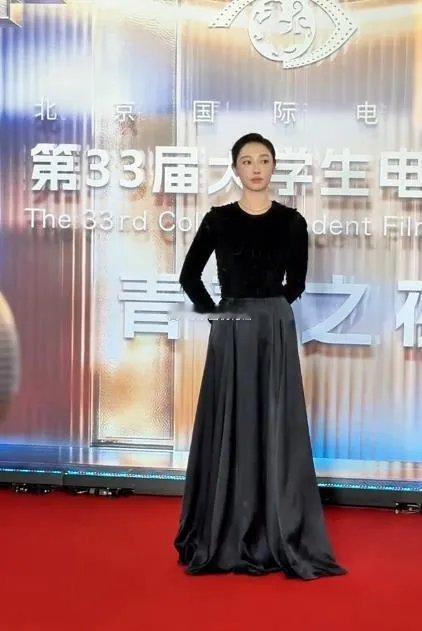 白百何现身第33届北京大学生电影节，一身全黑造型气场全开。黑色长袖上衣搭配丝缎半