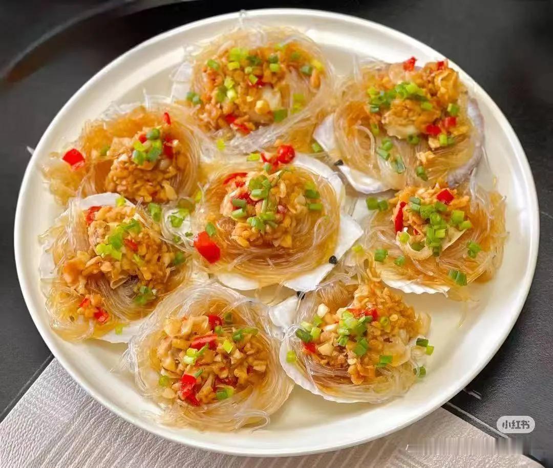 蒜蓉粉丝蒸扇贝‌：扇贝肉用料酒腌制10分钟去腥，粉丝泡软铺底，覆盖生熟蒜末混合的