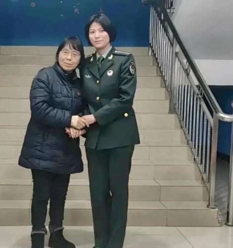 2025 年，华坪女高楼梯前，张桂梅校长紧握前来探望的学生丁王英的手，彼时的丁王