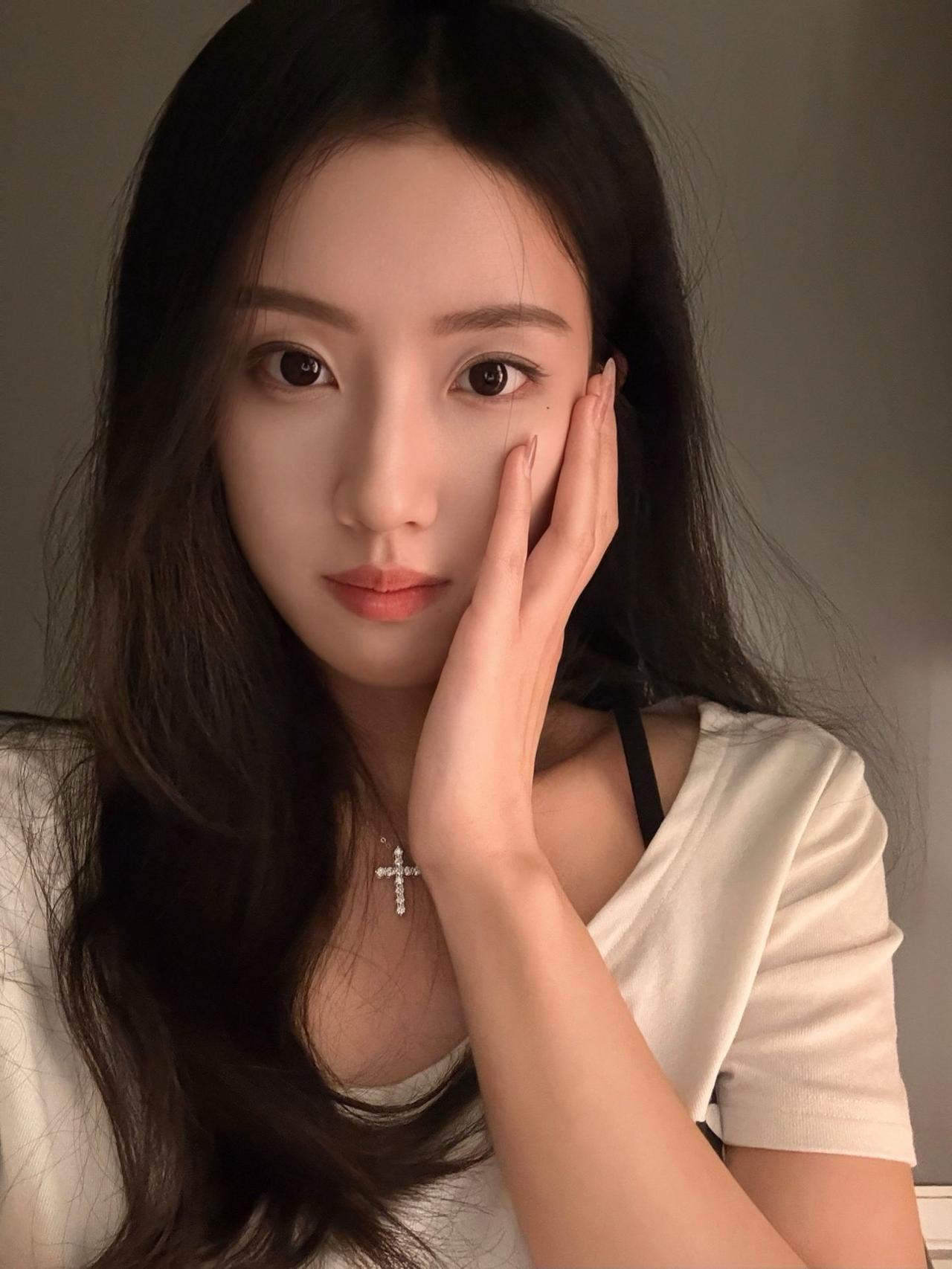 温柔甜美的少女，轻抚脸颊，散发自然魅力。