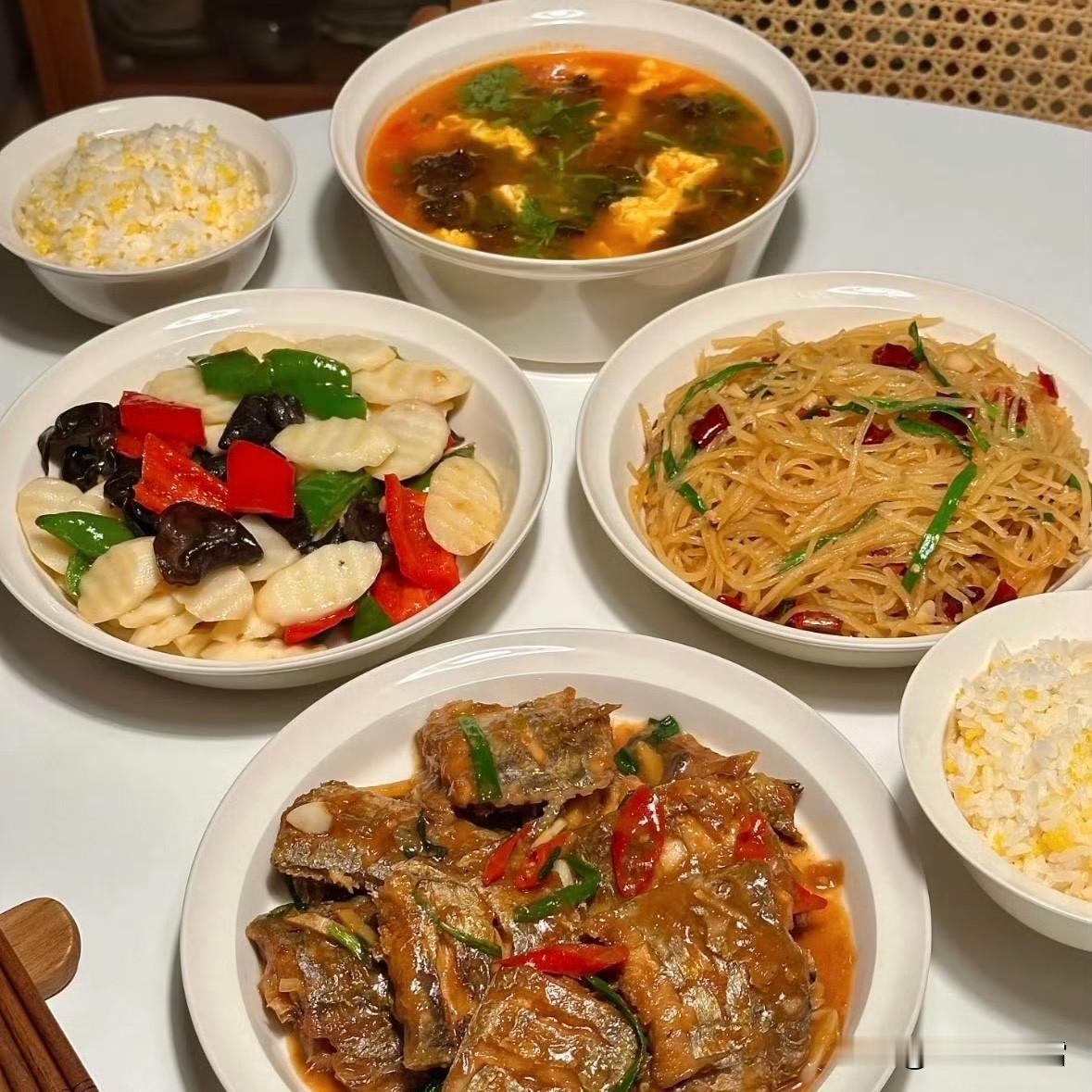 一桌是酸辣排骨配鲜香时蔬，瘦肉汤清润解腻；另一桌是红烧带鱼入味，酸辣土豆丝爽口，