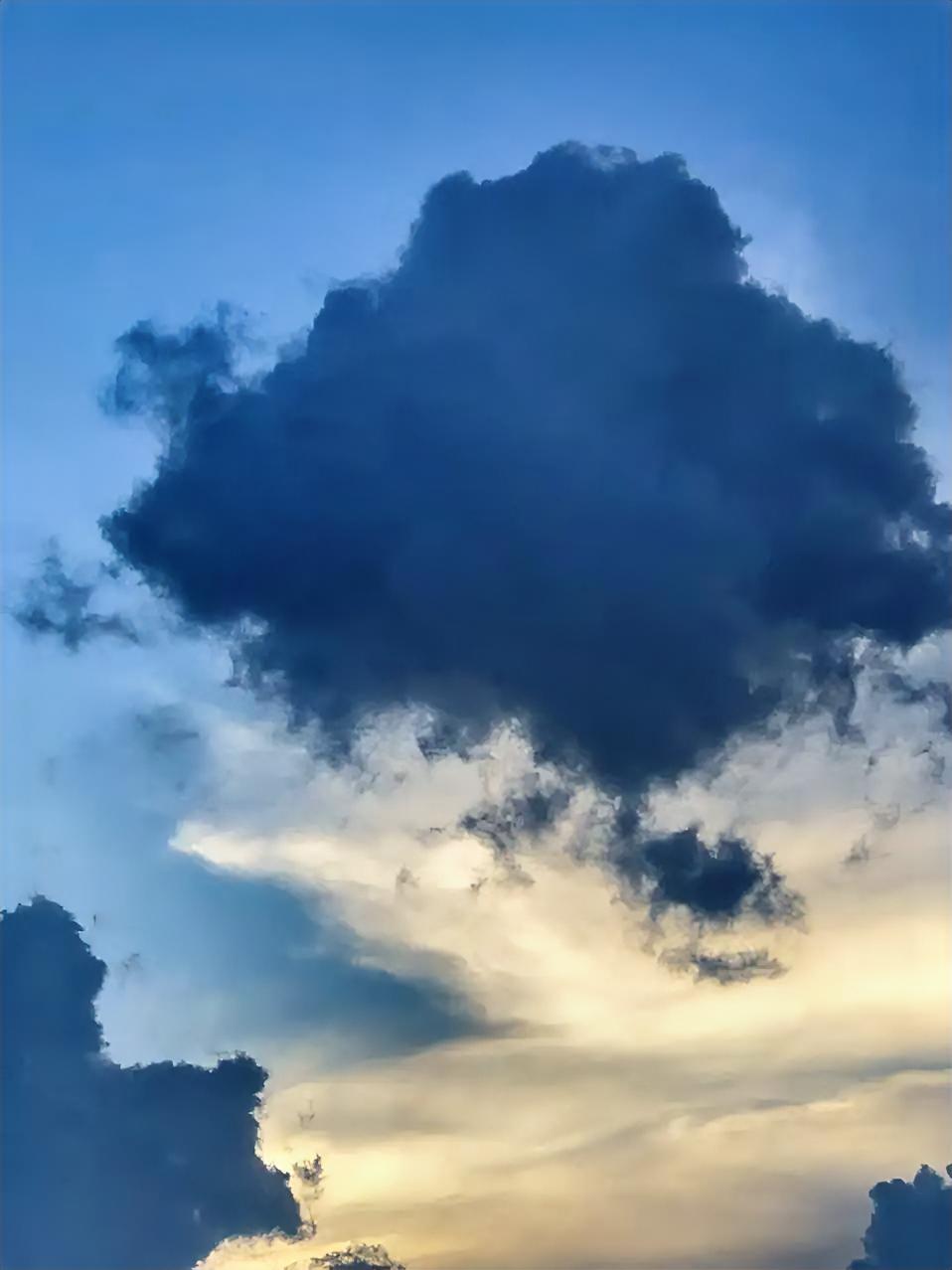 晚云
 
暮色把天空调成了温柔的蓝调，那团云却像被打翻了墨瓶，沉沉地悬着，边缘洇