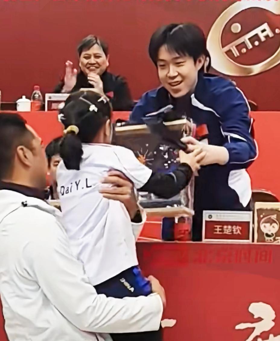王楚钦收到9岁粉丝的礼物，
赶紧起身双手接礼物，
并握手感谢，
就连后边的领导都
