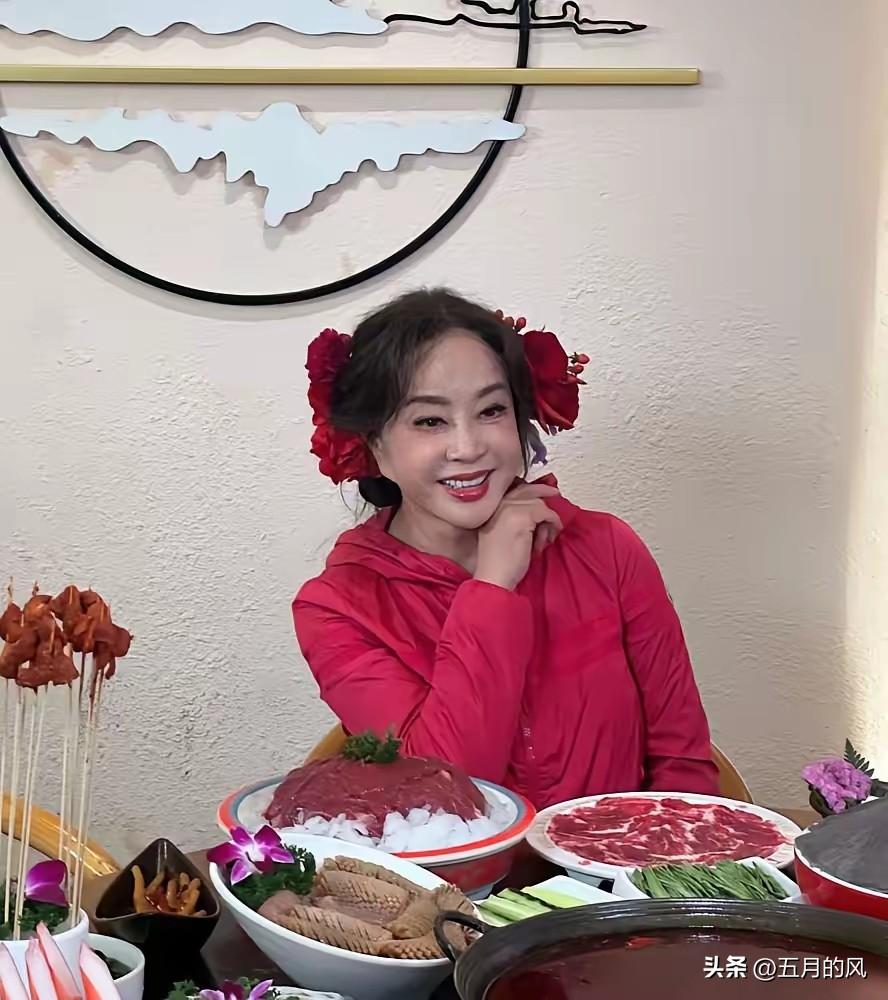 75岁的刘晓庆，一身红袄子衬得面若桃花，头上那几朵大红花插得比新娘子还热闹，走在