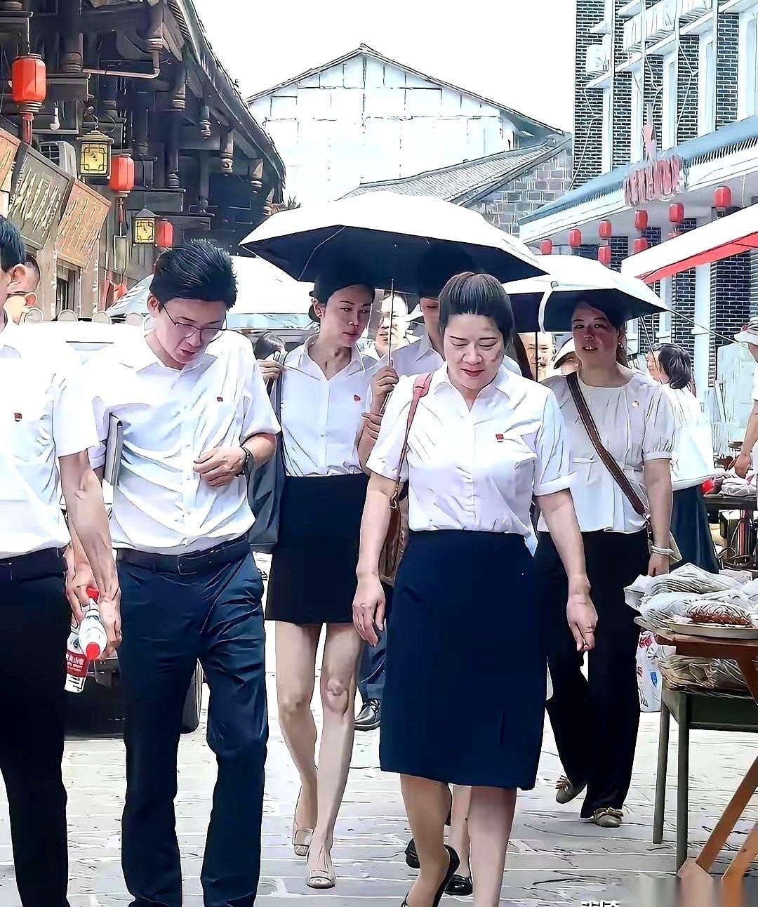 一张图，信息量有点大。
几个人，清一色工装，胸前徽章锃亮，一看就是下基层。问题来