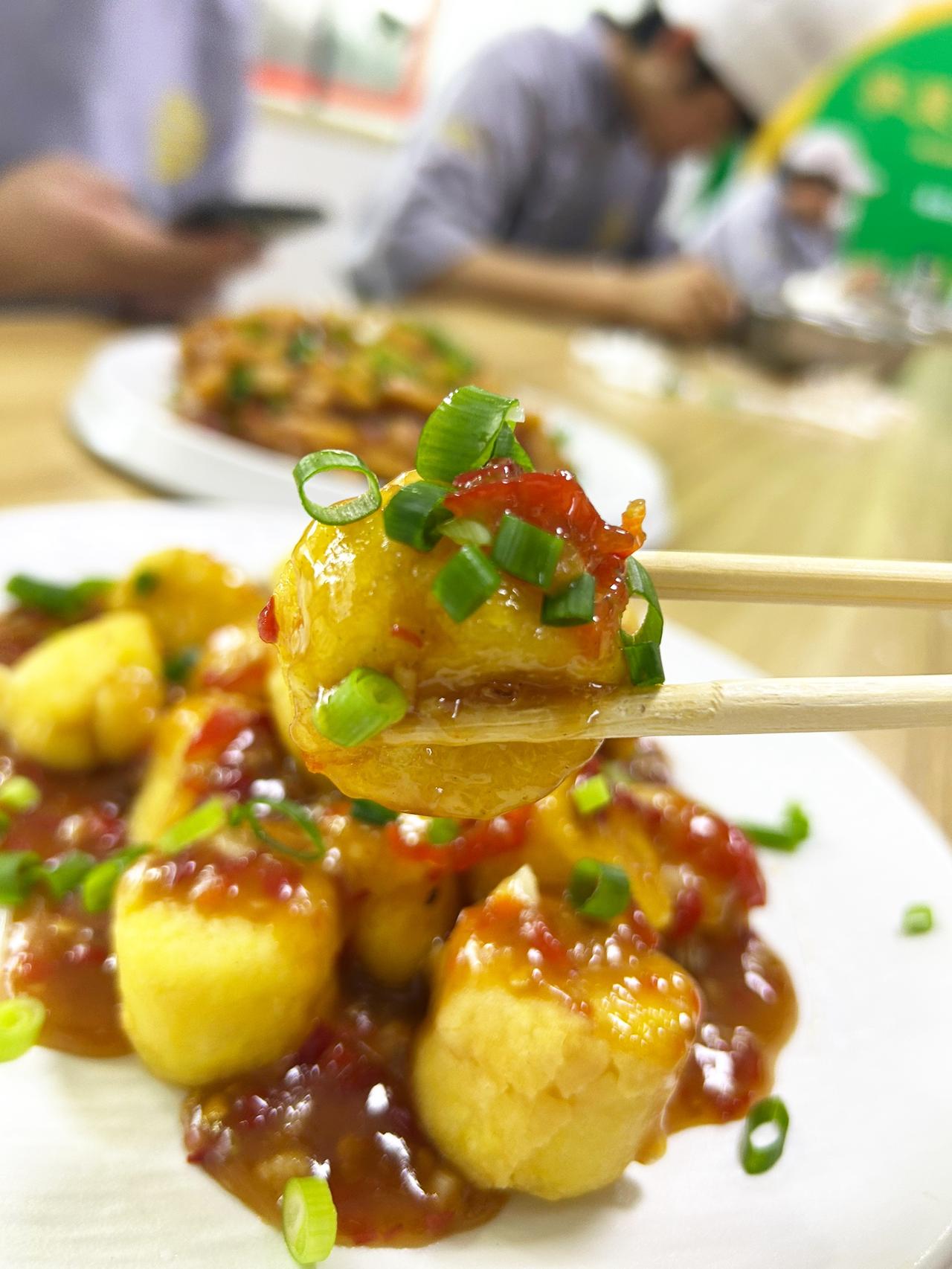 一盘糖醋土豆块，撒了葱花。